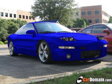 1997 Ford Probe - A blue 1997 Ford Probe is parked next to a red car in a lot.
