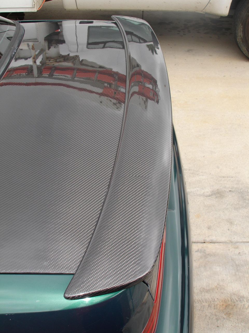 car trunk with carbon fiber spoiler, reflection of building in trunk lid
