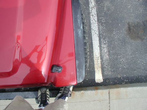 1998 Jeep TJ - Close-up view of the side of a red 1998 Jeep TJ, showing the fender and tire.