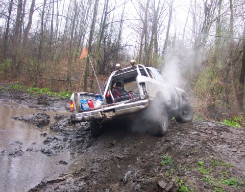 1978 Ford Bronco - Off-roading adventure: 1978 Ford Bronco navigates a muddy trail, emitting exhaust smoke.