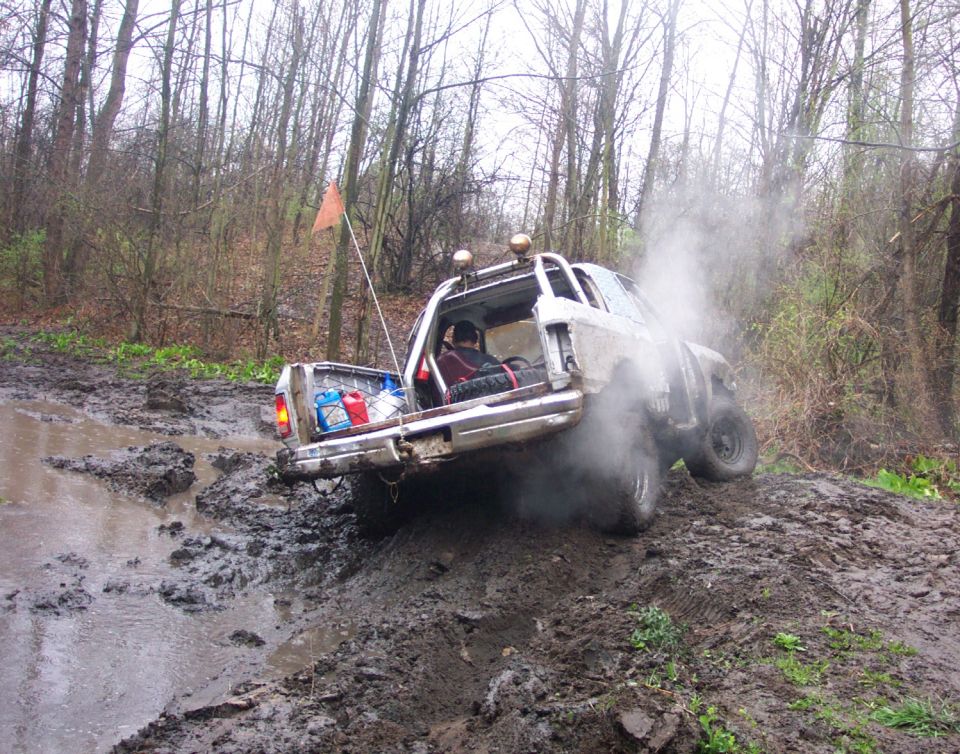 1978 Ford Bronco stuck in mud, rear view, exhaust smoke visible