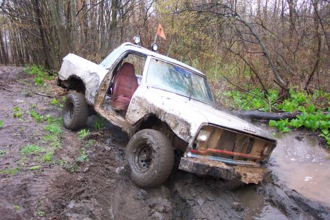 1978 Ford Bronco - This white pickup truck appears to be a 1979 model, not a 1978 Ford Bronco, as it navigates a muddy off-road trail.