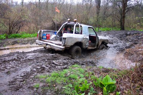 1978 Ford Bronco - This off-road vehicle is stuck in a muddy trail, with its front wheels submerged in water.