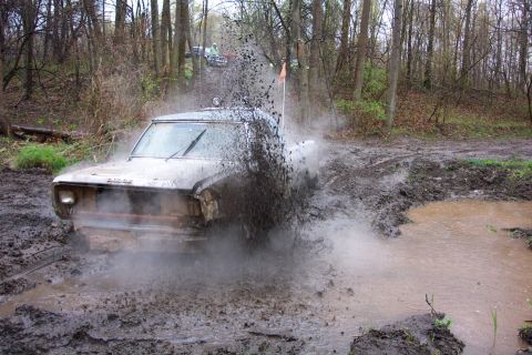 1978 Ford Bronco - A truck navigates a muddy trail, sending up a large spray of water and dirt.