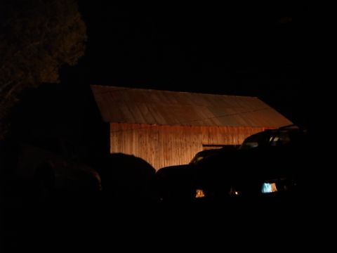 1988 Ford Bronco - Several vehicles are parked in front of a rustic barn, illuminated by an unseen light source at night.