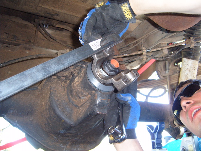 Mechanic working on a vehicle's rear differential with tools