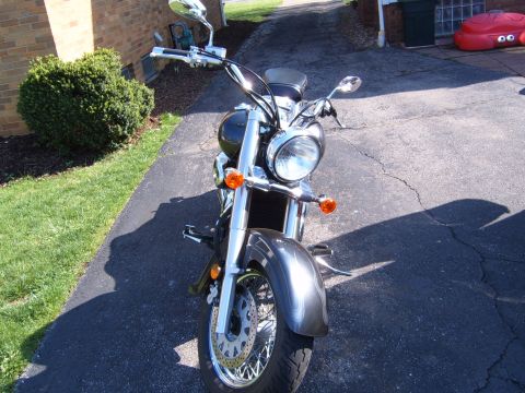 1993 Ford Bronco - A motorcycle is parked on a driveway in front of a brick building.