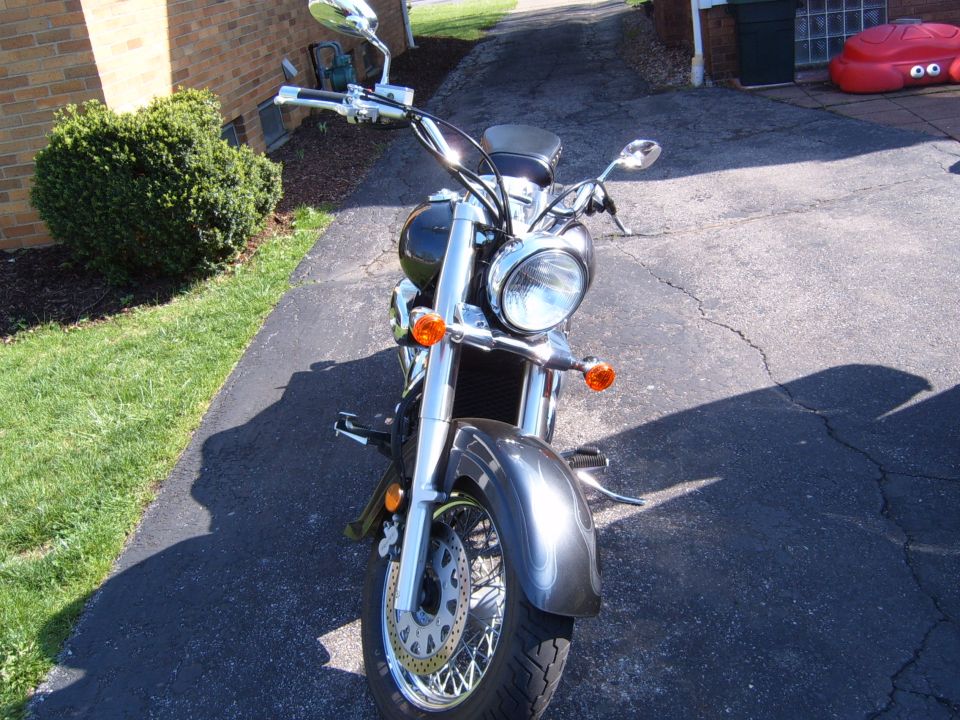Dark gray motorcycle front view, parked on asphalt driveway