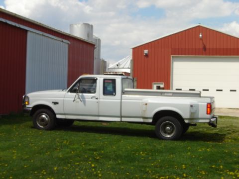1992 Ford Bronco - White 1992 Ford F-350 dually pickup truck parked in front of red barns.