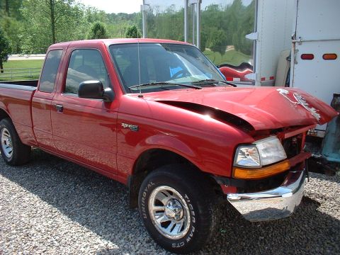 1999 Ford Ranger - This red Ford Ranger pickup truck has significant damage to its front end, including a severely dented hood.