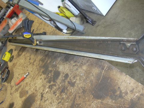 1991 Ford Bronco - A metal part, possibly a suspension component, is clamped to a workbench for modification or repair.