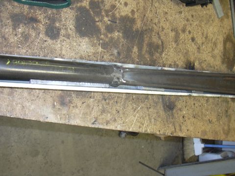 1991 Ford Bronco - A metal tube with a visible weld seam is shown on a work surface.