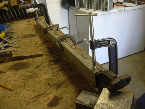 1991 Ford Bronco - A welding jig made from a metal beam held by clamps and a vise.