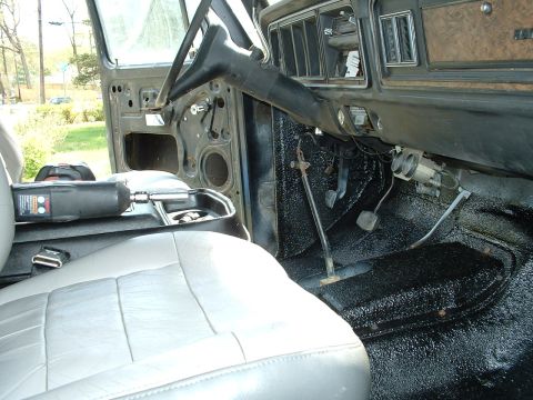 1978 Ford Bronco - The interior of a 1978 Ford Bronco, its dashboard, steering wheel, and light-colored seats.