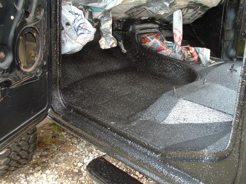 1978 Ford Bronco - The interior of the vehicle is being coated with a protective spray-on liner, with newspaper used to mask off the dashboard.