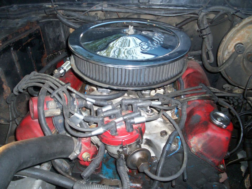 V8 engine bay with chrome Edelbrock air cleaner, red valve covers and spark plug wires