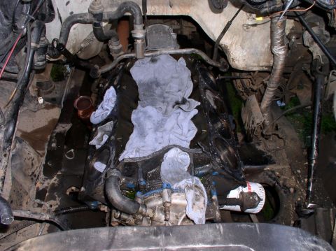 1988 Ford Bronco - Engine block with cylinder head removed, showing internal components and rags.