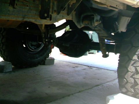 1989 Ford Bronco - Undercarriage view of a truck's rear axle and suspension system.