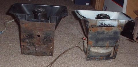 1997 Ford Crown Victoria - Two car horns, one black and one with a white interior, show significant rust on their metal mounting brackets.