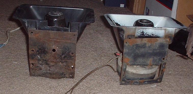 Two rusty car horns with black plastic housings and metal mounting brackets
