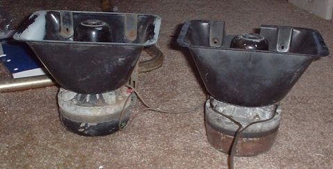 1997 Ford Crown Victoria - Two car horns are shown, each with a black plastic housing and a metal base.
