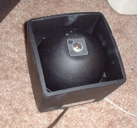 1997 Ford Crown Victoria - A black speaker component is shown in its housing, resting on a carpeted surface.