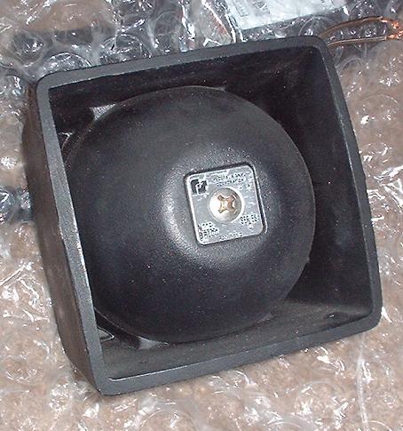 1997 Ford Crown Victoria - A black speaker is shown in its housing, with a metal label visible on the speaker's surface.