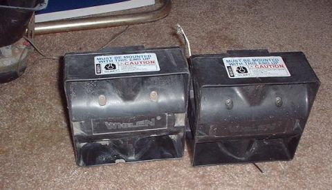 1997 Ford Crown Victoria - Pair of Whelen siren speakers, each with a caution label indicating proper mounting.