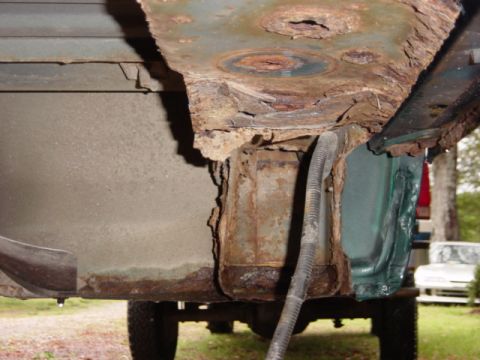 1991 Ford Bronco - The underside of a vehicle shows significant rust damage, with a second vehicle visible in the background.