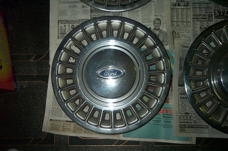 Ford hubcap with a chrome finish and a blue Ford logo in the center