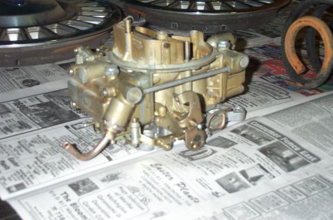 1991 Ford Crown Victoria LTD - A close-up view of a carburetor, likely for an older vehicle, placed on a surface covered with old newspapers.