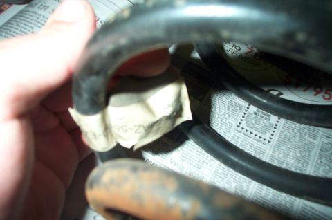 1991 Ford Crown Victoria LTD - Suspension spring part with label and newspaper classifieds in the background.