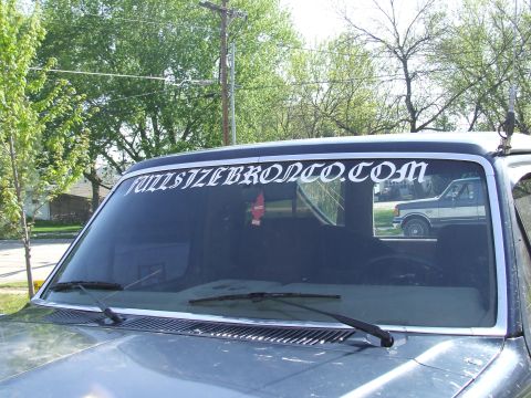 1986 Ford Bronco - Windshield banner advertises FULLSIZEBRONCO.COM, with a reflection of a 1987 Ford F-150 visible in the side window.