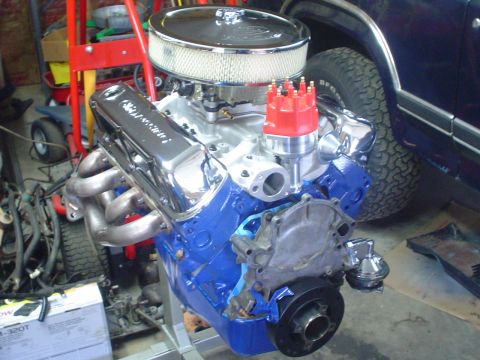 1984 Ford Bronco - Freshly rebuilt Ford small-block V8 painted blue on a stand in a garage, fitted with a chrome finned air cleaner, chrome Ford-script valve…