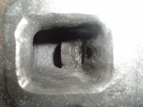 1984 Ford Bronco - Intake port of a cylinder head, showing internal casting details and wear.