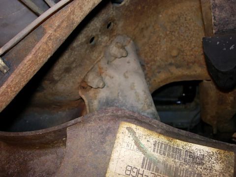 1993 Ford Bronco - Close-up view of a cracked Twin Traction Beam bracket on a 1993 Ford Bronco, showing significant rust.