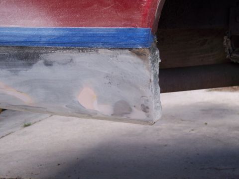 1972 Ford Ranchero - Detail of a vehicle's quarter panel undergoing repair, showing blue masking tape and applied body filler.