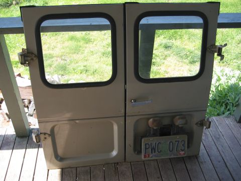 1991 Ford Explorer - Two vehicle doors with windows and a license plate are displayed outdoors on a wooden deck.