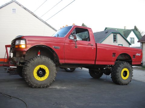1977 Ford F-150 - This red Ford pickup truck is heavily modified with a lift kit and oversized tires.