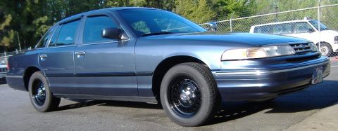 1996 Ford Crown Victoria - Side view of a blue 1996 Ford Crown Victoria with black steel wheels.