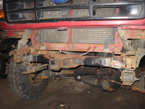 1977 Ford F-150 - The front end of a Ford truck is shown, with visible rust on the frame and radiator support.