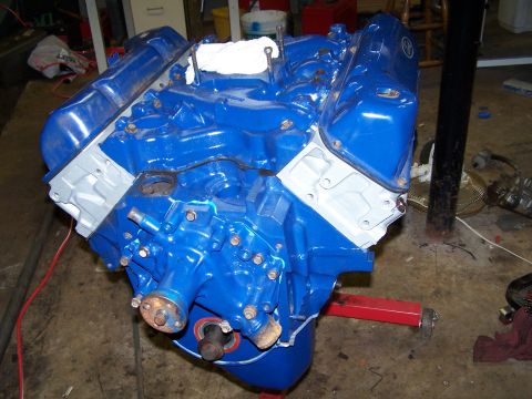 1979 Ford F-150 - A blue V8 engine is mounted on a red engine stand in a garage setting.