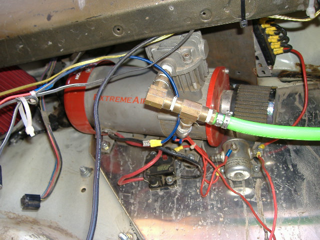 Extreme Air compressor with green hose and complex wiring harness mounted in vehicle