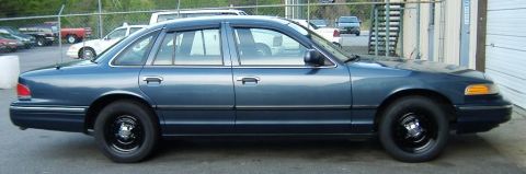 1996 Ford Crown Victoria - Side profile of a blue 1996 Ford Crown Victoria sedan parked outdoors.
