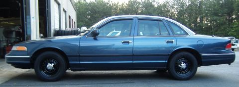 1996 Ford Crown Victoria - Side profile of a blue 1996 Ford Crown Victoria sedan parked outdoors.