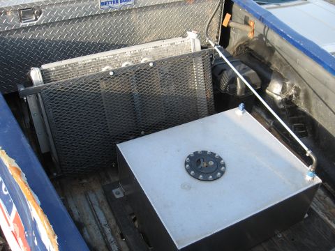 1977 Ford F-150 - A large aluminum fuel tank and a radiator are installed in the bed of a pickup truck.