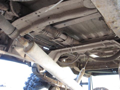1977 Ford F-150 - The underside of a 1977 Ford F-150 reveals its exhaust system and suspension components.
