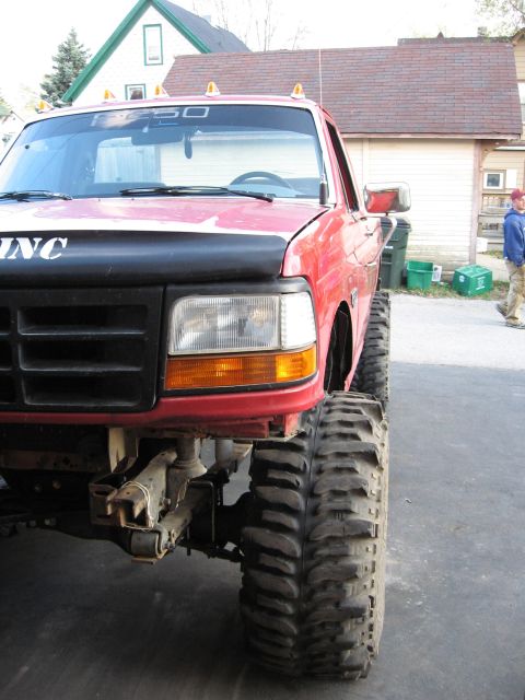 1977 Ford F-150 - This red Ford pickup truck features a lifted suspension and oversized off-road tires.