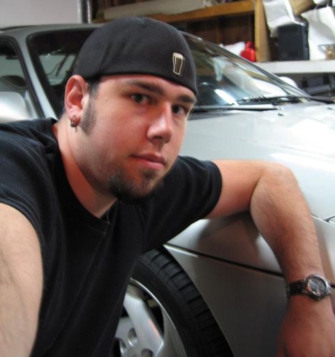 1994 Ford Probe - Man poses with a silver car in what appears to be a garage. Supermotors logo is visible.