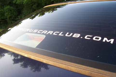 1993 Ford Taurus - A white decal on the rear window of a car reads TAURUSCARCLUB.COM.